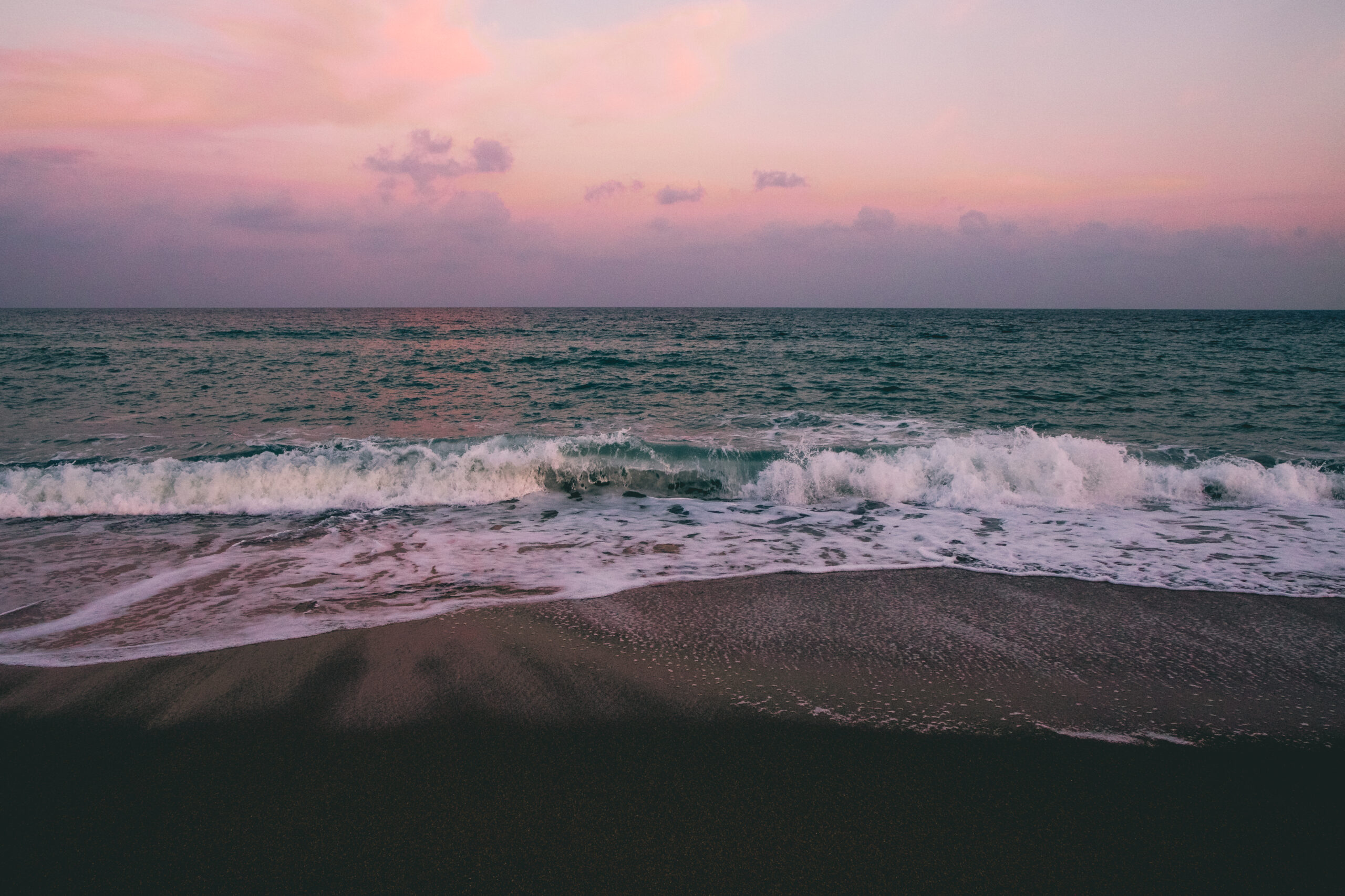 Wellen brechen am Strand von Barcelona im Abendrot